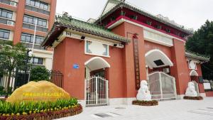 un bâtiment en briques rouges avec un panneau devant lui dans l'établissement Guangzhou YuXiang Apartment - Guangzhou Pazhou International Convention and Exhibition Center, à Canton