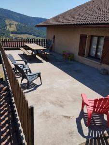 un grupo de sillas y una mesa de picnic en un patio en Maison de montagne en Bussang