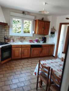 a kitchen with wooden cabinets and a sink and a chair at Maison de montagne in Bussang