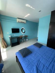 a blue bedroom with a bed and a desk at GazStation in Kata Beach
