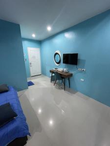 Habitación azul con escritorio y TV. en GazStation, en Kata Beach