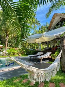 a hammock in front of a resort with a pool at Maddekehaoo Eco Mansion in Ko Chang