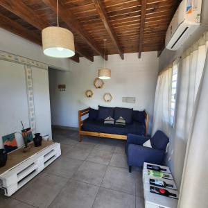 uma sala de estar com um sofá azul e uma cama em DEPARTAMENTO Mendoza em Las Heras
