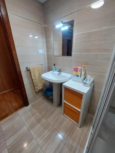 a bathroom with a sink and a toilet and a mirror at Tiviti playa ribadesella in Ribadesella