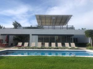a house with a swimming pool and chairs and a building at Departamento exclusivo de lujo jardín y terraza gh3 in Guadalajara