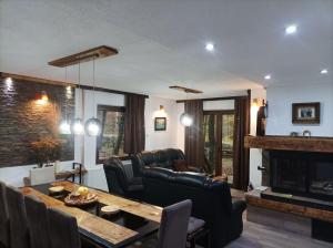 a living room with a table and a fireplace at Vila KTM Lisine in Despotovac