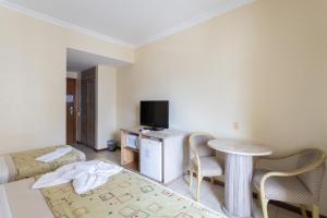 勒西菲的住宿－Flat Costa Mar，客房设有1张床、1张桌子和1台电视。