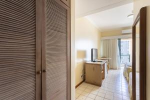 a hotel room with a sliding door with a television at Flat Costa Mar in Recife
