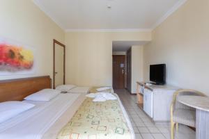 Habitación de hotel con cama y TV en Flat Costa Mar en Recife