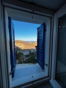 an open window with a view of a field from a house at Kioura's home in Ano Syros