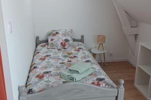 ein kleines Schlafzimmer mit einem Bett mit Blumenbettdecke in der Unterkunft Le Goh Reste, agréable maison de campagne in Locmaria-Grand-Champ