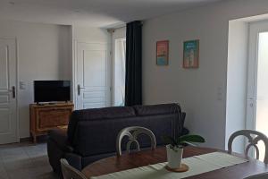 ein Wohnzimmer mit einem Sofa und einem Tisch in der Unterkunft Le Goh Reste, agréable maison de campagne in Locmaria-Grand-Champ