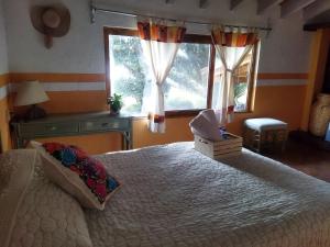 ein Schlafzimmer mit einem großen Bett und zwei Fenstern in der Unterkunft Casa los Olivos in Tepoztlán