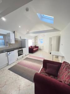 a living room with a couch and a kitchen at Cozy Luxury Private Cottage in Greenford