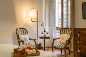 a bedroom with two chairs and a table and a lamp at Holiday Home Adelaide in Pienza