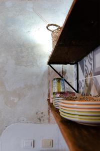 a kitchen with a shelf with plates of food at Holiday Home Adelaide in Pienza
