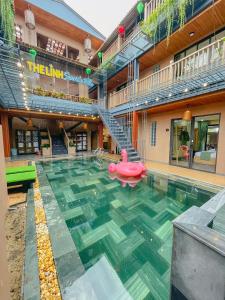 ホイアンにあるThe Linh Seaside Villa Hoi Anのピンクの浮き輪が浮かぶスイミングプール