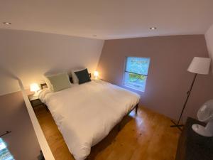 Un dormitorio con una gran cama blanca y una ventana en B&B In de aap gelogeerd, en Apeldoorn