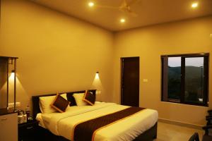 a bedroom with a bed and a window at CeeCee Grand Resort in Vagamon