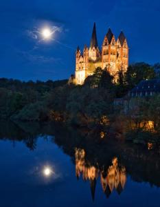 a castle lit up at night with a full moon at Wohnung in Elz in Elz