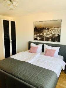 a bedroom with a large bed with pink and white pillows at MILA-Appartement in Karlsruhe