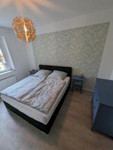 a bedroom with a bed and a chandelier at Burg Stargard Zwei Zimmer Wohnung in Burg Stargard