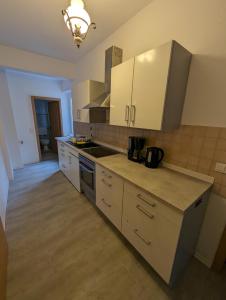 a kitchen with white cabinets and a counter top at Burg Stargard Zwei Zimmer Wohnung in Burg Stargard