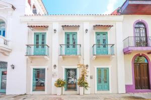 a white house with blue windows and balconies at Casa Azul - Apartamento de 2 Pisos, 2Hab con Rooftop en Casco Antiguo in Panama City
