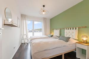 a bedroom with two beds and a large window at Design-Apartment - Küche - Dachterrasse - zentral in Leinfelden-Echterdingen