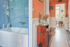 ein Badezimmer mit blauen Fliesen und einer Badewanne und einem Waschbecken in der Unterkunft Le Marine - Maison avec jardin Disney & Paris in Le Perreux-sur-Marne + 36 Fotos