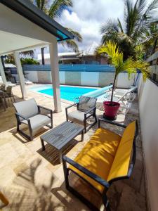 a patio with chairs and a table and a pool at La Caz' Miness in Saint-Louis