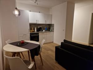 a kitchen and a living room with a table and a couch at Auszeit Penthouse-Feeling in Esslingen