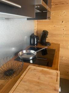 a kitchen with a pan on top of a stove at Cosy Mountain _ free park in Montgenèvre