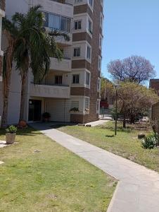 a building with a palm tree next to a sidewalk at La casa de Emma in Cordoba