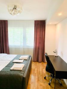 a bedroom with a bed and a desk with a table at MILA-Appartement in Karlsruhe