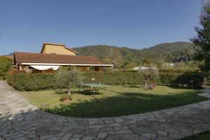 un giardino con tavolo e una casa di CàMia Lovely house ValDiVara 5Terre hiking a Sesta Godano