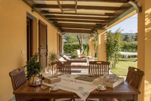 a wooden table and chairs on a patio at CàMia Lovely house ValDiVara 5Terre hiking in Sesta Godano +35 photos