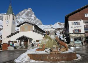 a statue of horses in front of a building with a mountain at Cervinia in residence in Breuil-Cervinia