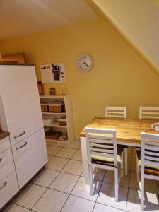 a kitchen with a table and a clock on the wall at Ruhrpottbude - Private Ferienwohnung im Herzen des Ruhrgebiets in Bochum