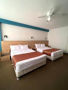 una camera con 2 letti e un ventilatore a soffitto di Costa Bella a Ilo