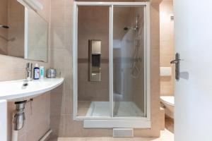 La salle de bains est pourvue d'une douche avec une porte en verre. dans l'établissement Studio sur les quais de Seine, à Paris