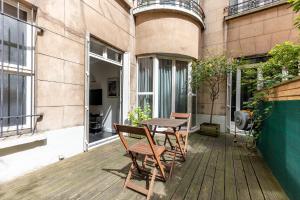 d'une terrasse avec une table et des chaises sur un balcon. dans l'établissement Studio sur les quais de Seine, à Paris