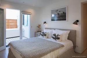 een slaapkamer met een groot bed met witte lakens en kussens bij On the Beach , in Saint Barth... Mellow Mood Villa in Saint Barthelemy