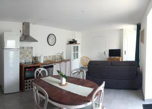 eine Küche und ein Wohnzimmer mit einem Tisch und einem Sofa in der Unterkunft Le Goh Reste, agréable maison de campagne in Locmaria-Grand-Champ