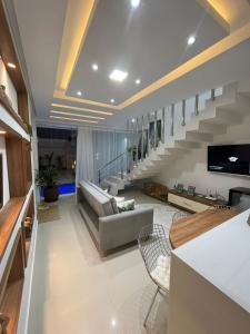 a living room with a couch and a staircase at Casa Brilho da Lua - 3 Suítes, apenas 300m da Praia in Porto Seguro