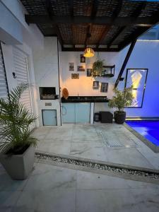 a patio with potted plants and a swimming pool at Casa Brilho da Lua - 3 Suítes, apenas 300m da Praia in Porto Seguro