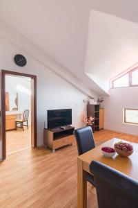 a living room with a dining table and a television at Todorka Apartments in Bansko in Bansko