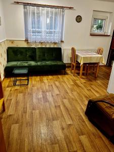 a living room with a green couch and a table at Vila Adéla - Teplice in Teplice