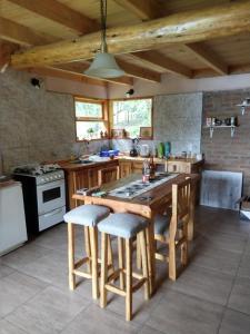 Una cocina con una gran mesa y sillas de madera. en Mirador de la montaña, en Los Repollos