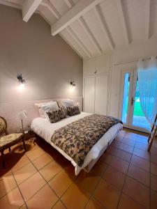 a bedroom with a large bed and a chair at Villa Paulen Pausa in Uhart-Cize +26 photos